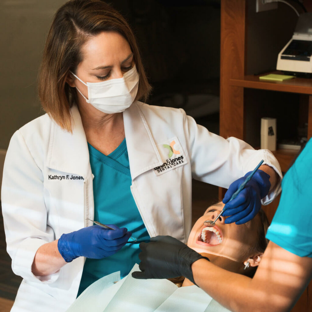 Skilled female dentist performing a professional dental procedure with precision and care, wearing protective gear in a modern treatment room