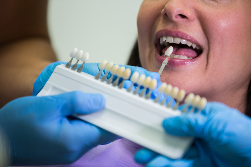 Dentist examining female patient with veneers at dental clinic