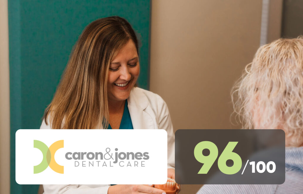 Best dentists in Kokomo, Indiana. Caron and Jones Dental Care smiling together in their office, wearing professional uniforms