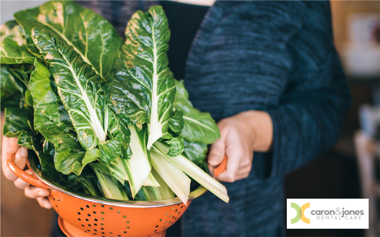 Smiling woman carrying fresh green leafy vegetables outdoors