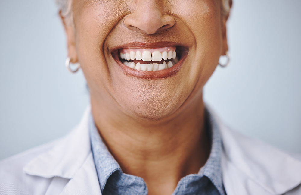 Dental, smile and elderly woman in studio for mouth, hygiene and denture care against grey background