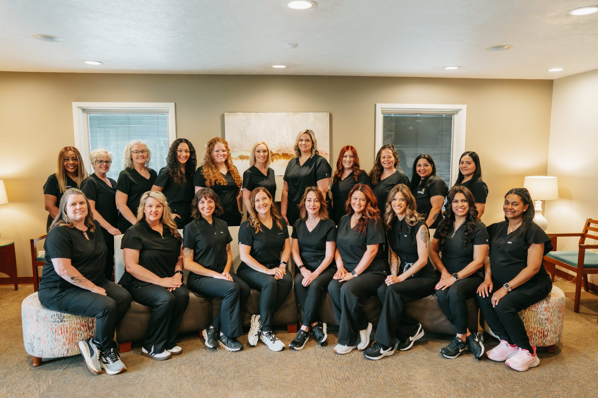 Group of smiling dental professionals from Caron & Jones Dental Care pose together in a welcoming office setting